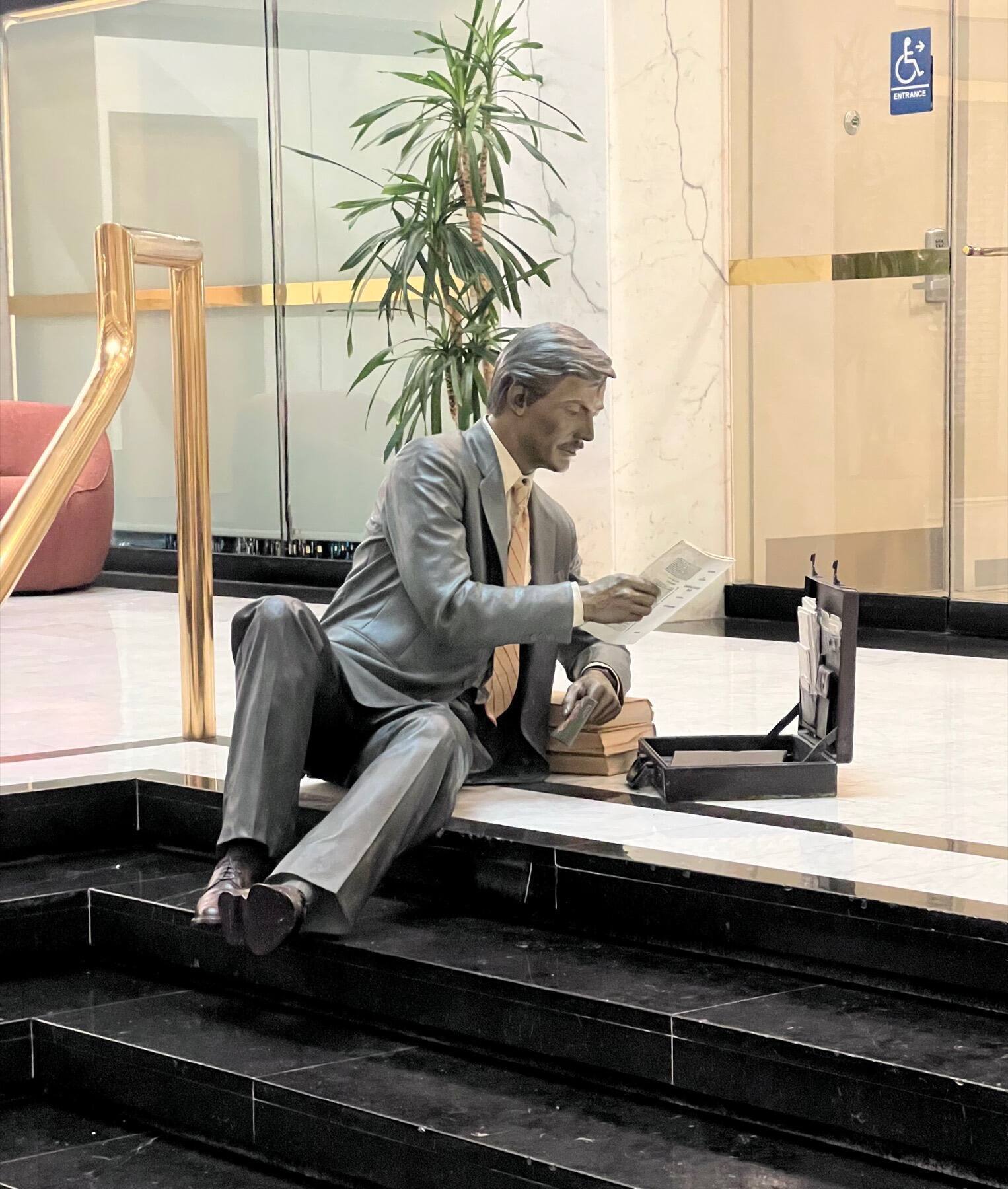 Businessman reading newspaper, Philtower Building Lobby