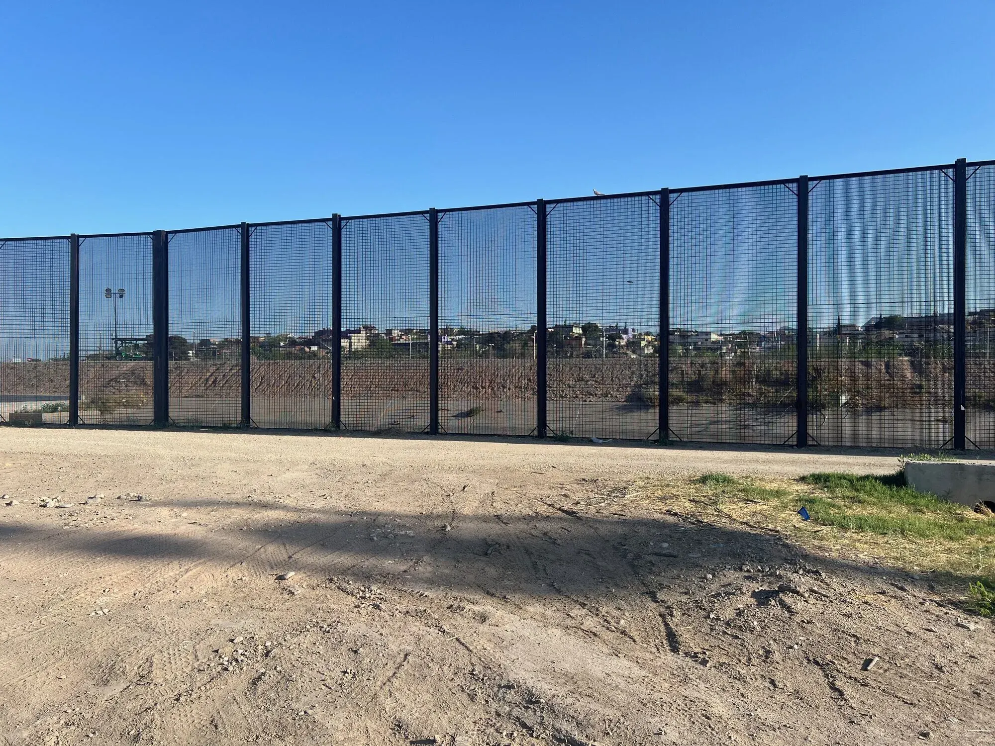 Border fence along a dirt access road, El Paso