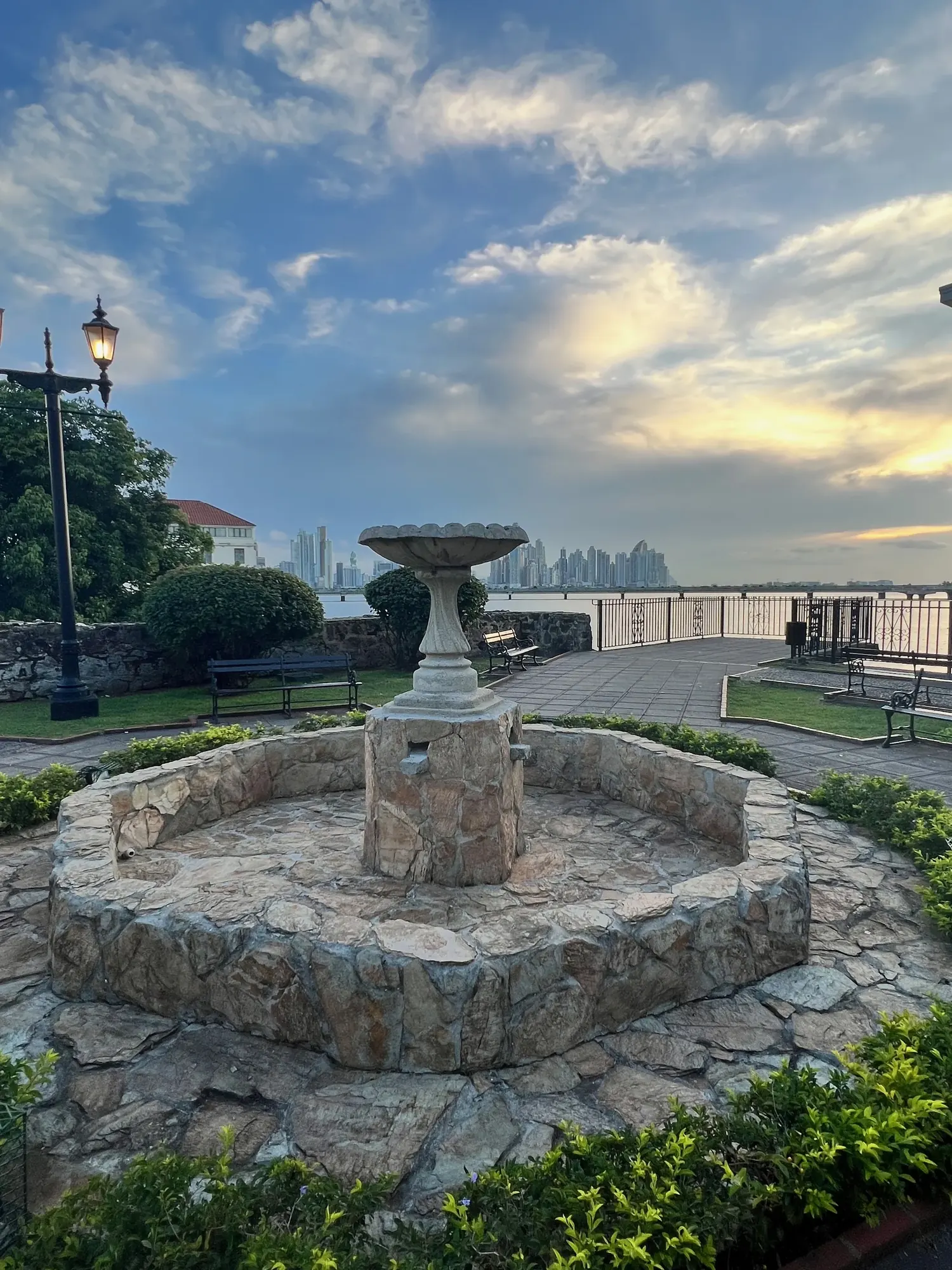 A stone fountain overlooking the Panama City skyline at dusk