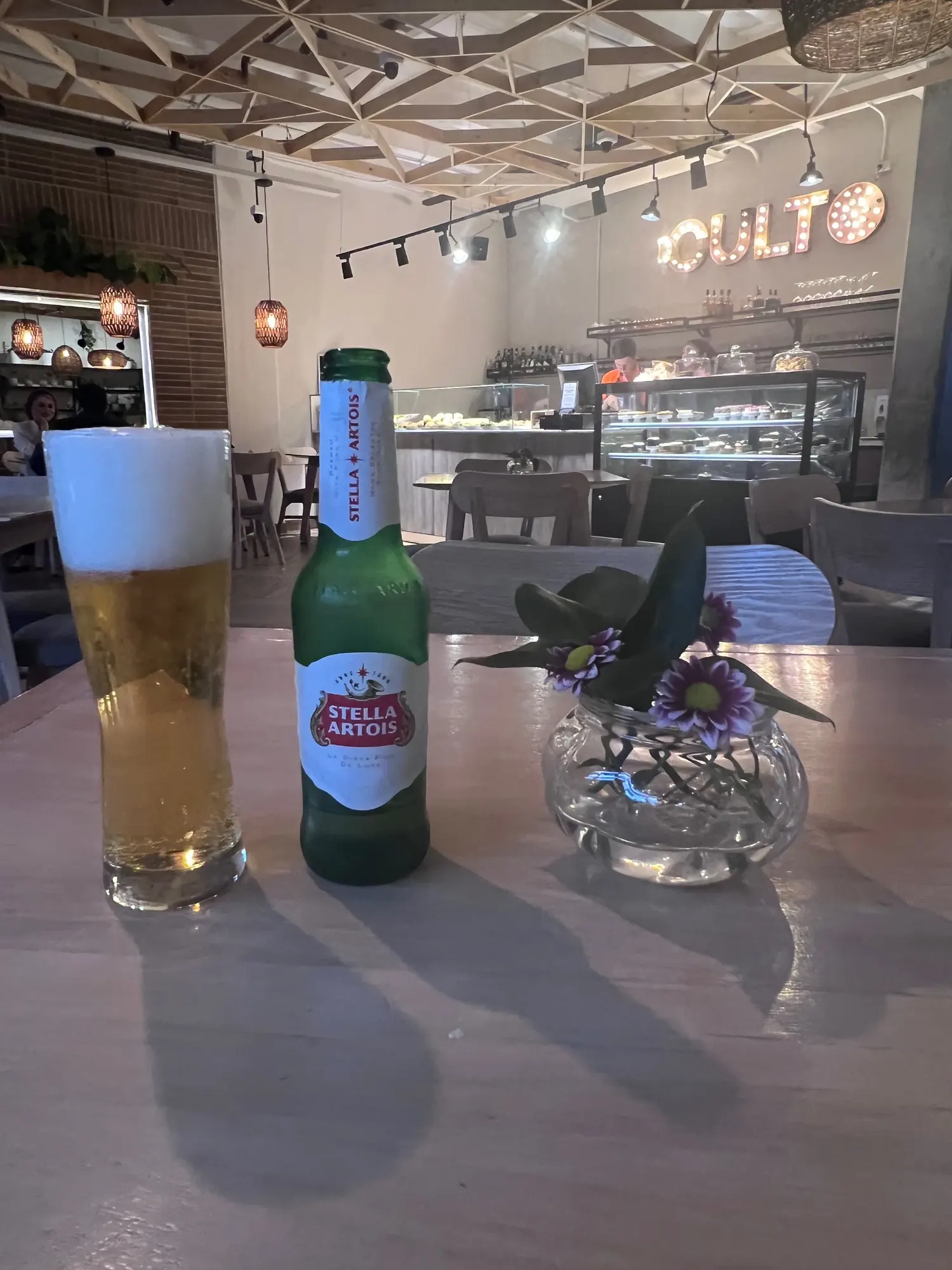 A beer on the table at Culto cafe in Bogota, with the Culto sign visible behind