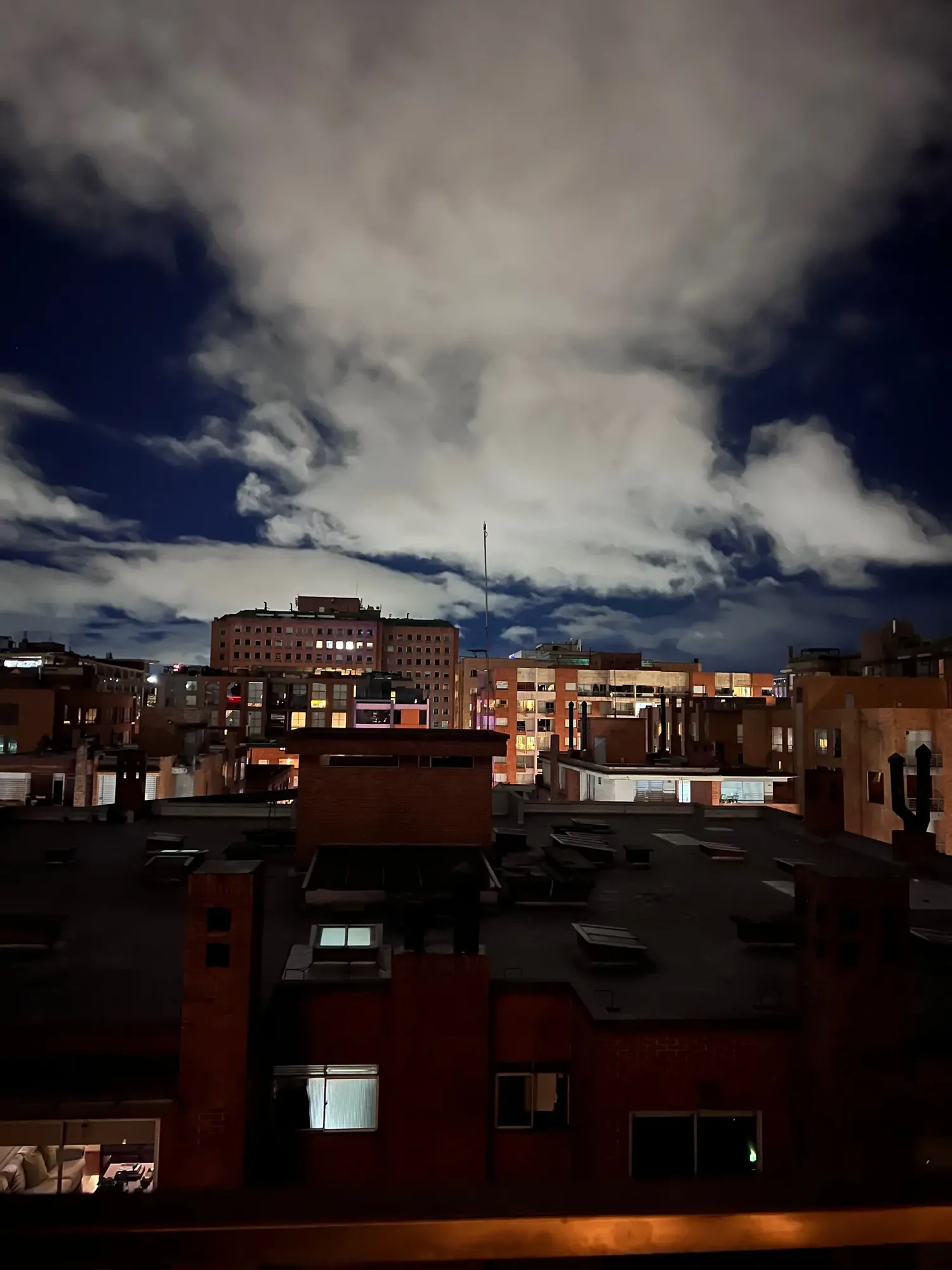 Nighttime view of Bogota rooftops from an apartment window
