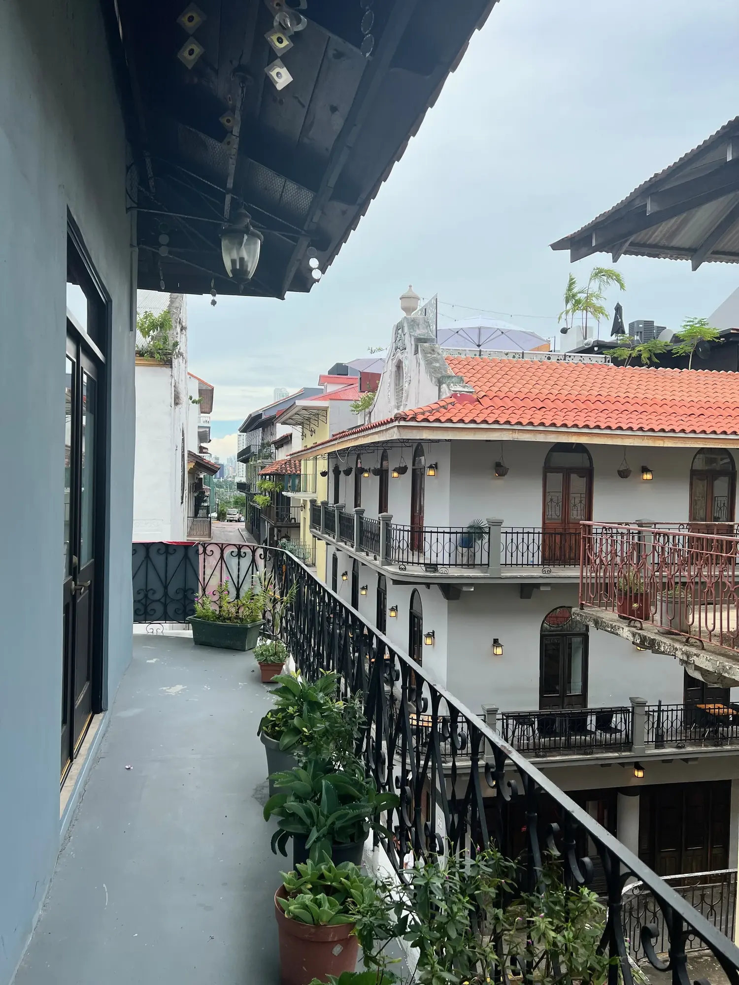 Morning view from a Casco Viejo balcony across rooftops, pale sky overhead