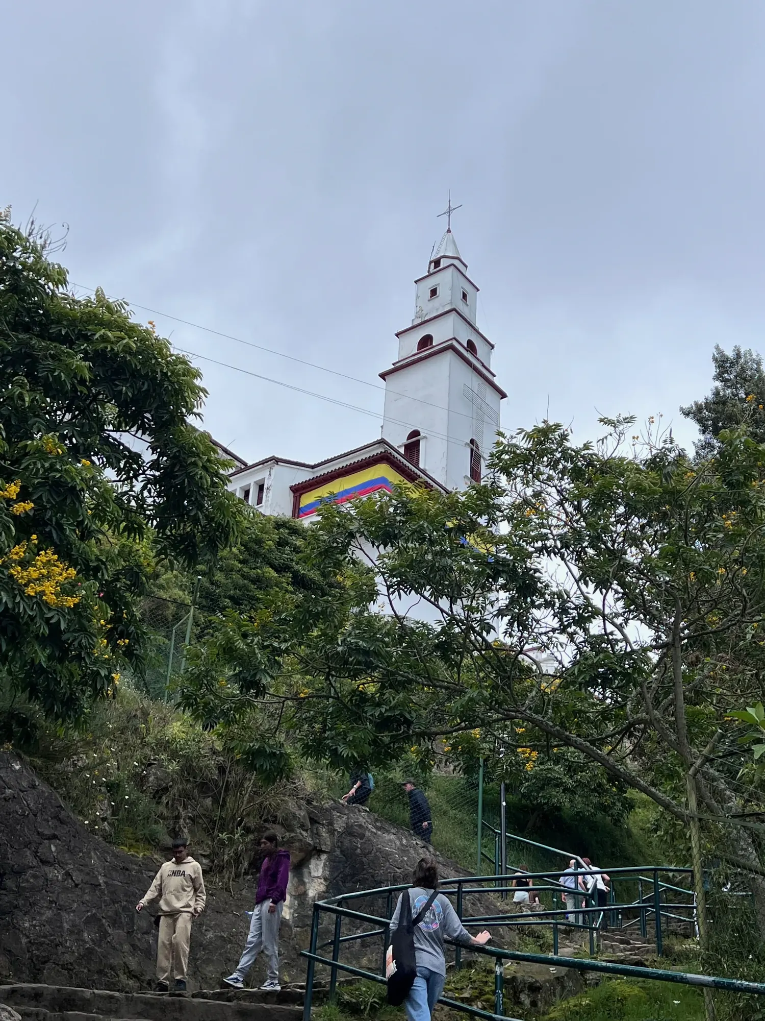 The Monserrate church tower seen through trees along the path